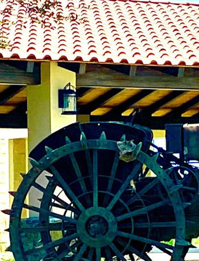 Rueda antigua de implemento agrícola bajo palapa